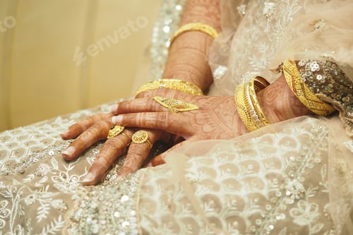 Preview: Exquisite bridal hands adorned with gold jewelry during celebration