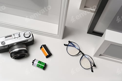 Preview: Eyeglasses, camera and picture frame on white background.