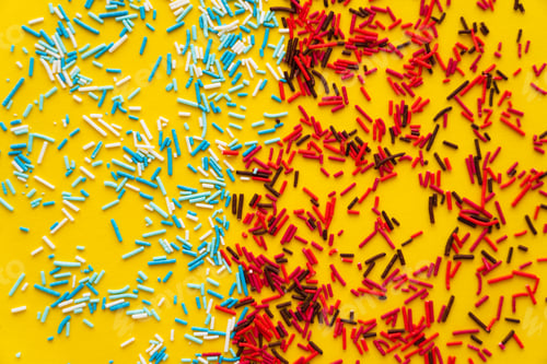Preview: Top view of colorful sweet sprinkles on yellow background