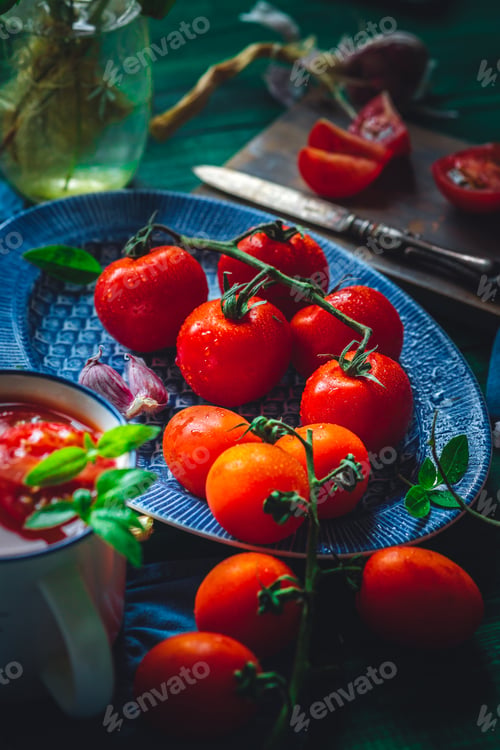 Preview: multicolored tomatoes on a branch prepared for making tomato juice on a wooden background