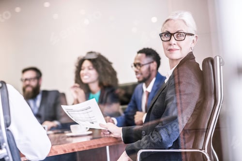 Preview: Businesswoman looking over her shoulder in board team meeting