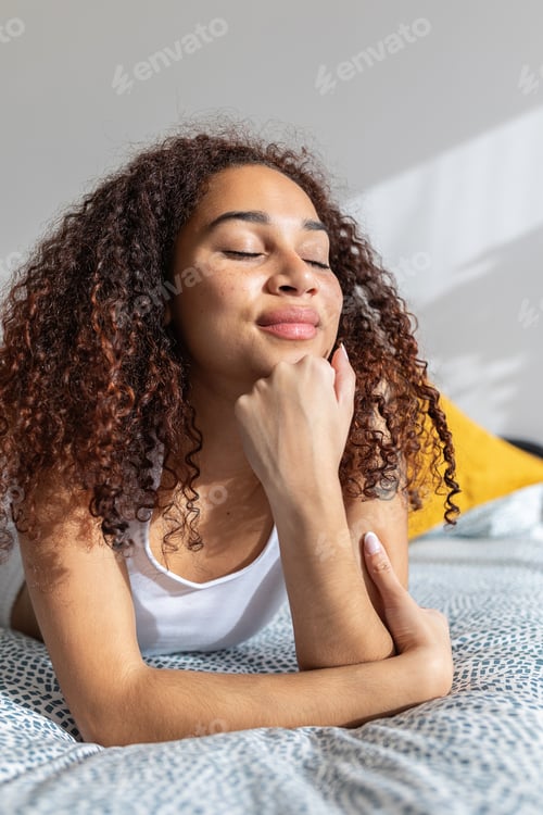 Preview: Happy young latin girl with closed eyes enjoying sunlight in the morning