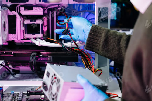 Preview: Closeup of technician repairing computer power supply in modern tech lab, symbolizing