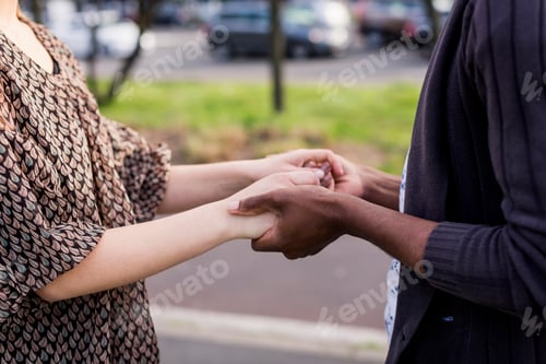 Preview: Mid section of romantic young couple holding hands in city