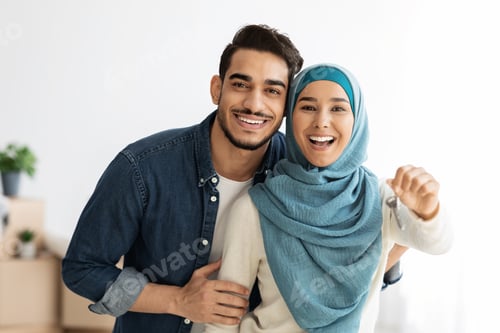 Preview: Emotional young lady in hijab showing key from house