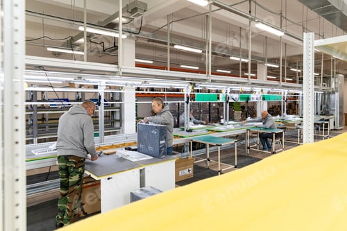 Preview: Photo of a plant for assembling monoblocks for computers. Working men work on the conveyor