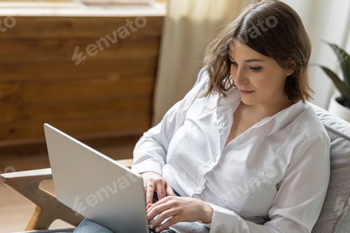 Preview: Young beautiful smiling woman using laptop. Concept of freelance, home office