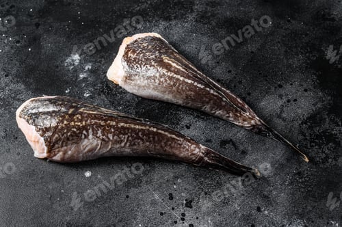 Preview: Raw monkfish without a head. Black background. Top view
