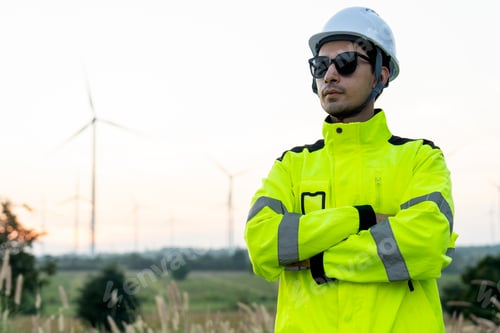 Preview: Portrait of wind turbine worker or technician man stand with arm-crossed and look to his right side