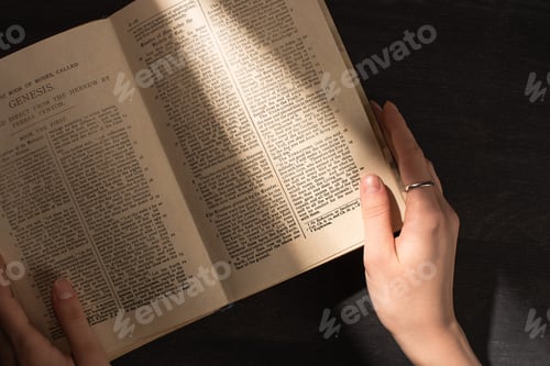 Preview: KYIV, UKRAINE - JANUARY 17, 2020: partial view of woman reading holy bible in dark