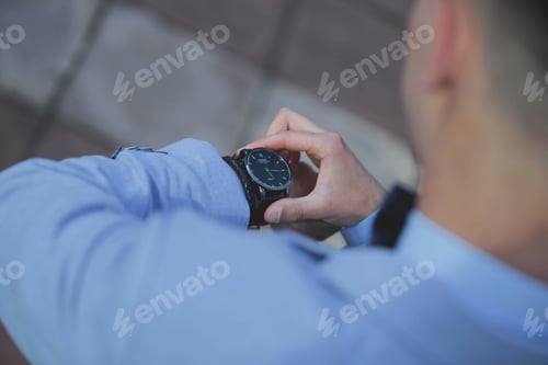 Preview: Closeup shot of a groom looking at his watch