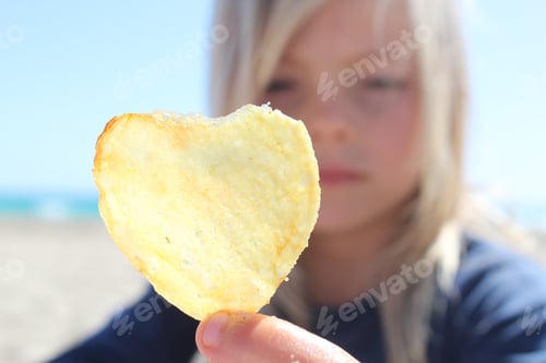 Preview: Girl holding up a heart shaped crisp