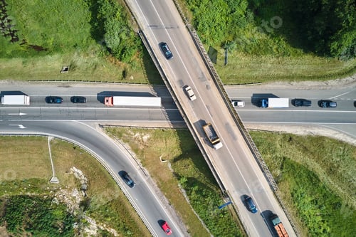 Preview: Aerial view of road intersection with fast moving heavy traffic on city streets.