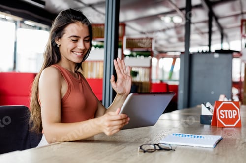 Preview: A young girl waves a webcam in a tablet computer, holding a virtual online meeting with her friend