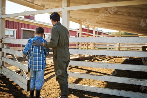 Preview: Caucasian Man Guiding Caucasian Boy While Walking Together on Farm Outdoors