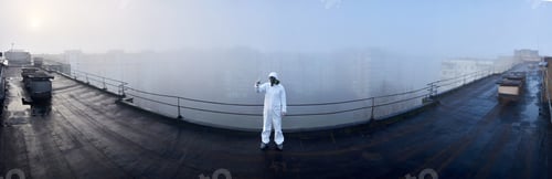 Preview: Worker scientist wearing protective coverall and gas mask doing ecological tests on the roof