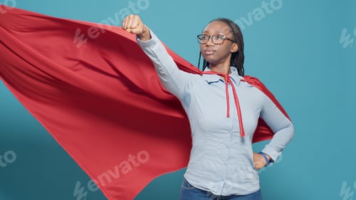 Preview: Portrait of superhero with flying red cape on camera