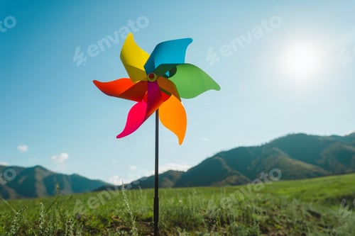 Preview: Windmill against, pinwheel the backdrop of green mountains and sky
