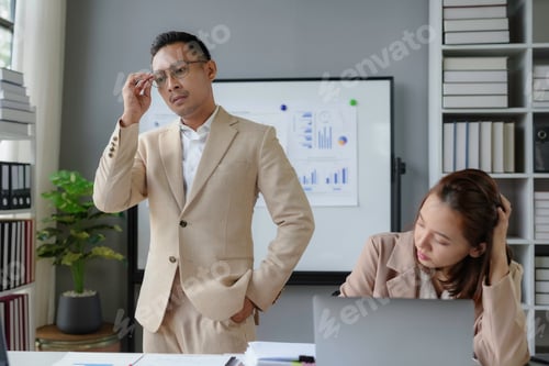 Preview: Pensive businessman adjusting glasses while businesswoman getting stressed at work