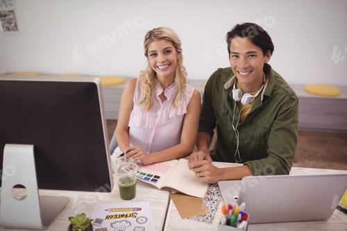 Preview: Portrait of smiling coworkers working together at creative office
