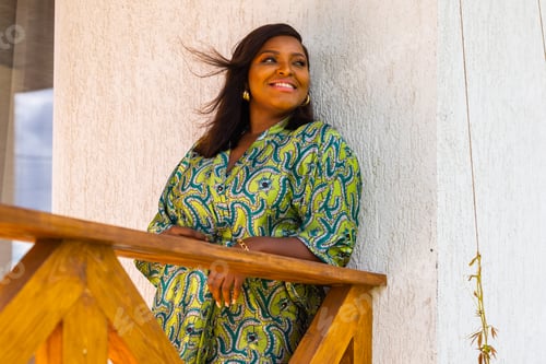 Preview: African american woman relaxing and enjoying sun while standing at terrace or balcony at sunlight at