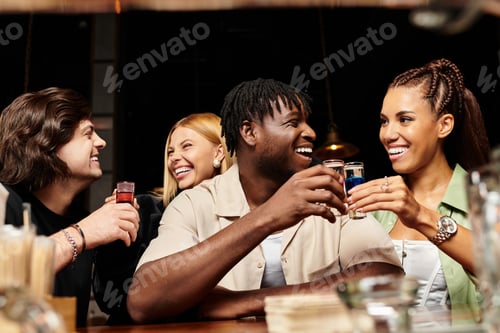 Preview: Diverse colleagues celebrating together with drinks at a lively corporate party in the evening