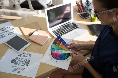 Preview: Female executives holding color shade swatch at her desk