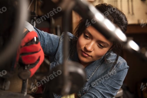 Preview: Female mechanic working on motorcycle in workshop