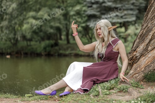 Preview: Young elf girl with blond long hair. Beautiful medieval elven princess in a burgundy dress