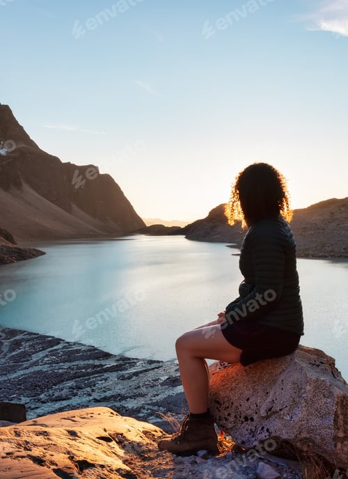 Preview: Adventurous Caucasian Adult Woman Hiking on top of a Canadian Rocky Mountain