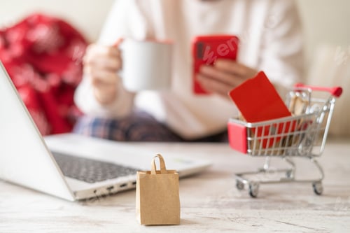 Preview: Holiday online shopping concept with woman browsing with laptop, smartphone, and credit card