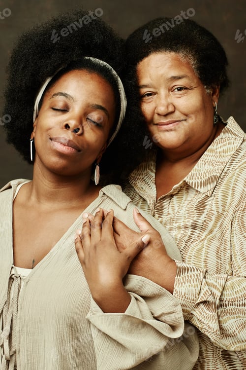 Preview: Portrait of Two Black Women Embracing on Brown Background