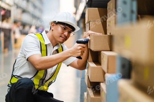 Preview: Male warehouse worker with barcode scanner in a large warehouse.