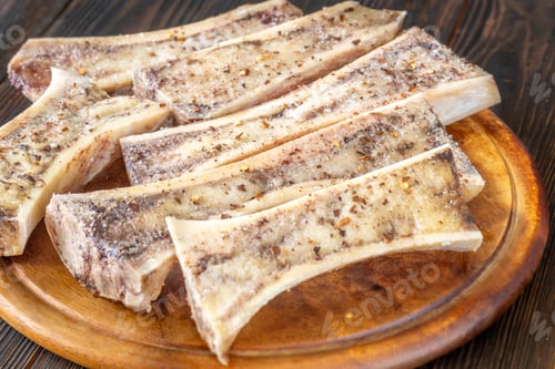 Preview: Rustic roasted marrow bones rest on warm wooden board, savory richness revealed