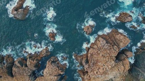 Preview: Azure waves foaming rocks top view. Relaxing blue ocean rolling washing cliffs.