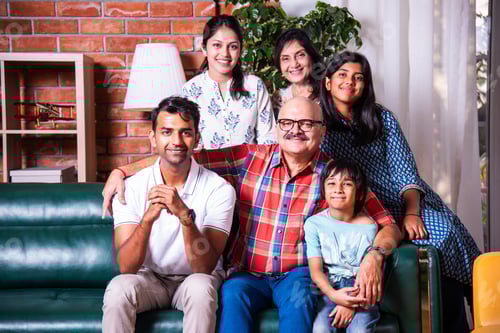 Preview: Happy Indian asian family consists of grandparents, parents, kids posing for photo sitting on sofa