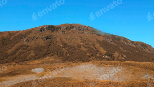Preview: Colorful autumn vegetation in a mountainous area. Clip. A sunny day, blue sky and golden hills.