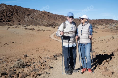 Preview: Active retired senior couple with backpack walking outdoors in Teide volcano area in Tenerife
