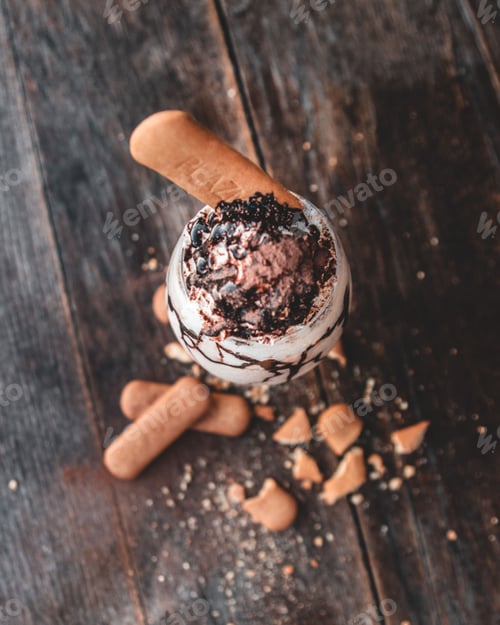Preview: Top view of yummy tiramisu milkshake on wooden surface