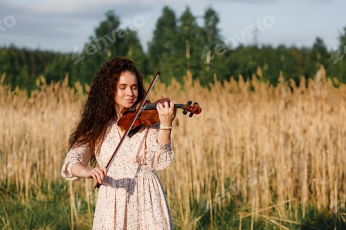 Preview: The brunette girl with a violin outdoor.