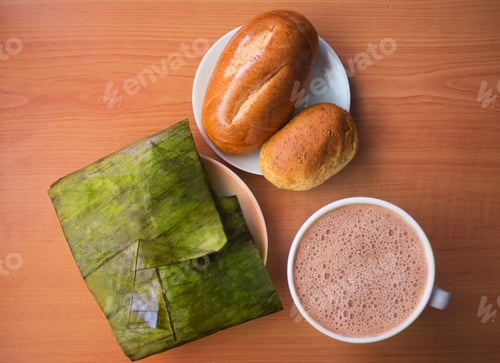 Preview: Top view of delicious colombian tamales, with fresh bread and coffee on a wooden surface