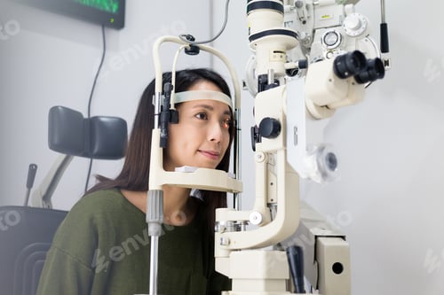 Preview: Woman doing eye test in optical clinic