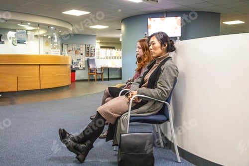Preview: Two people sitting in a waiting area of a medical practice