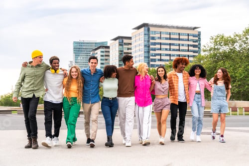 Preview: Happy playful multiethnic group of young friends bonding outdoors