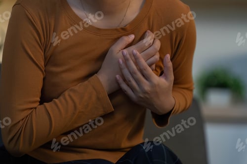 Preview: Health Awareness: Young woman experiencing chest discomfort at home