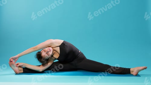 Preview: Calm adult stretching legs and arms muscles on floor mat