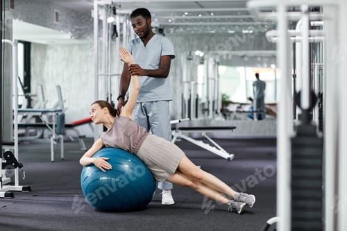 Preview: Woman Works with Therapist at Gym on Ball