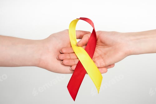 Preview: cropped view of man and woman holding red and yellow ribbon as hepatitis c awareness isolated on