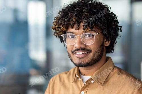Preview: Close-up portrait of young hispanic man wearing glasses, man smiling and looking at camera at
