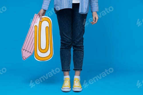 Preview: Concept of school and education, girl with decorative paper clip and pencil on blue background
